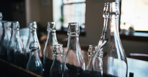 Clear glass bottles lined up on a bar