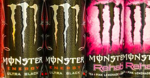 Close-up of four cans of Monster energy drink in a row.