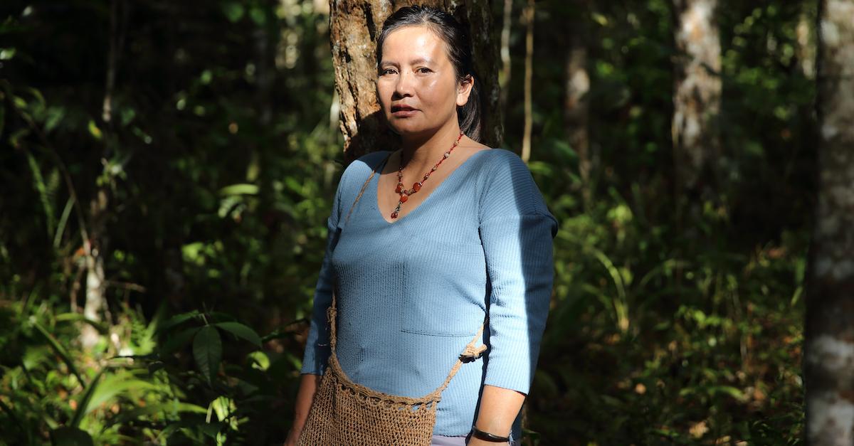 Delima Silalah wears a blue shirt in a rainforest.