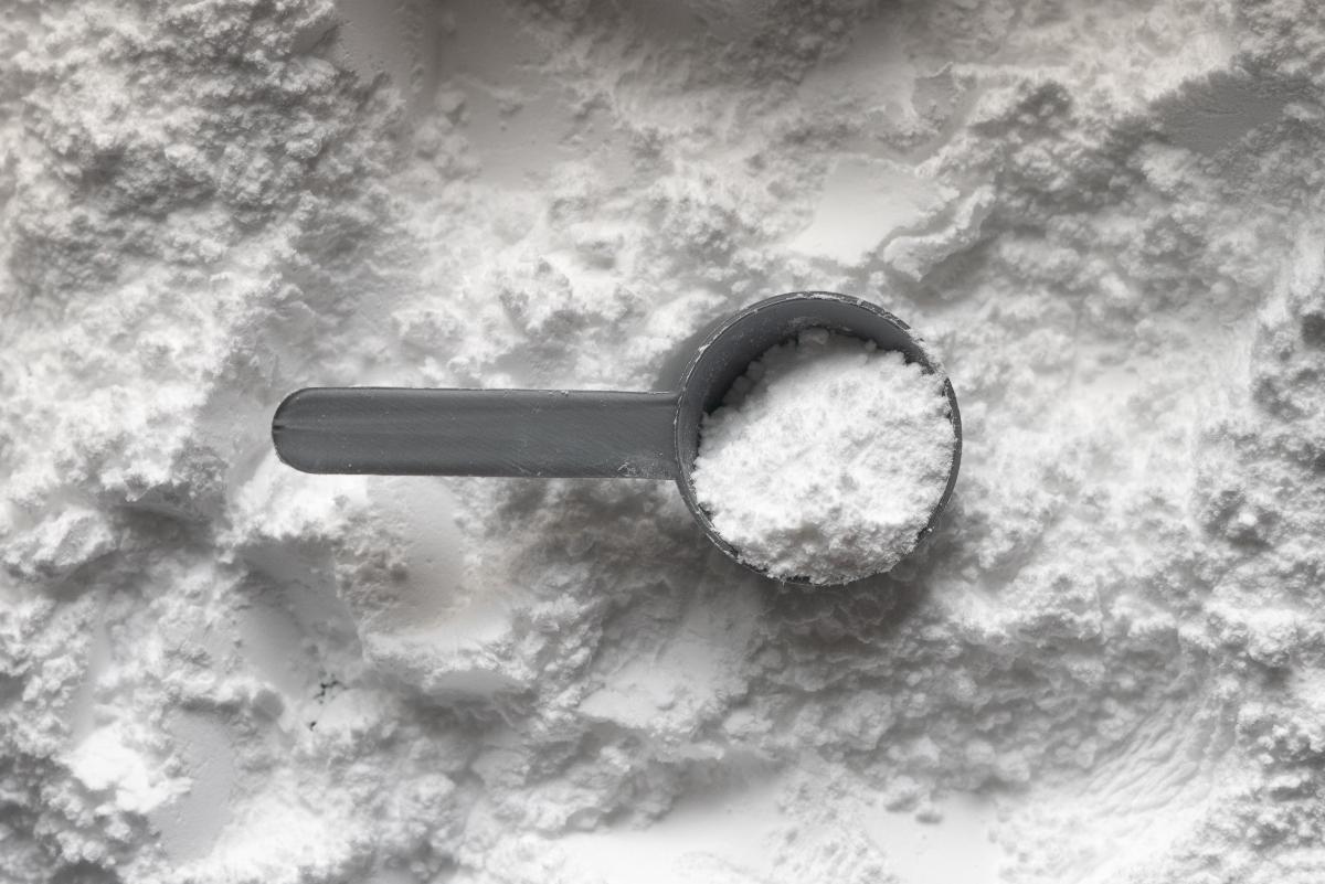 grey scoop of white creatine powder supplement