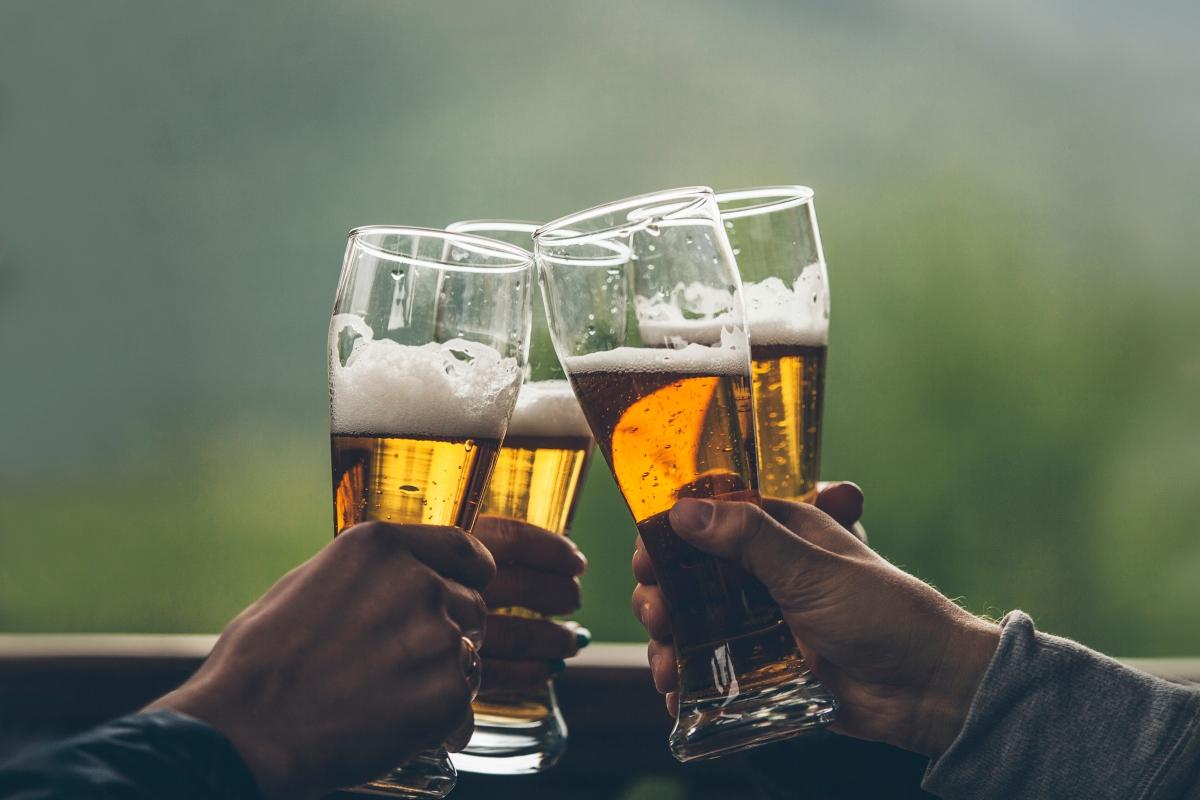 four hands toasting with beer glasses