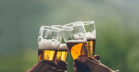 four hands toasting with beer glasses