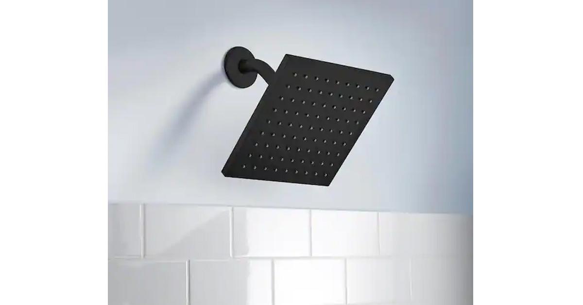 Black rain shower head on white tiles.