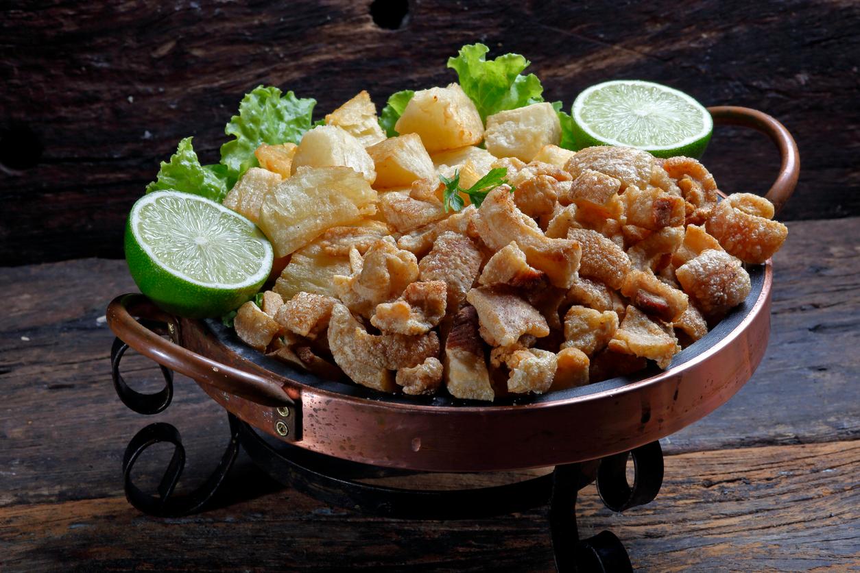 Fried cassava is served on a plate with lime wedges and lettuce. 