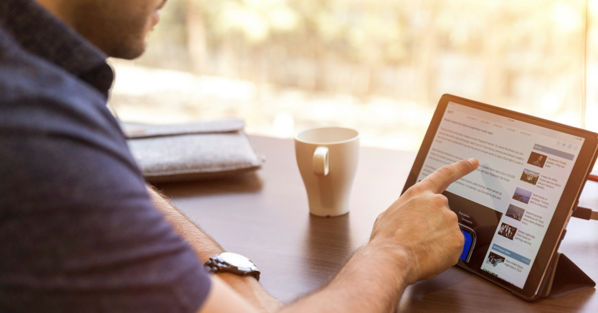 A man scrolls the internet on his tablet