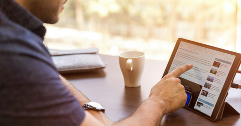 A man scrolls the internet on his tablet