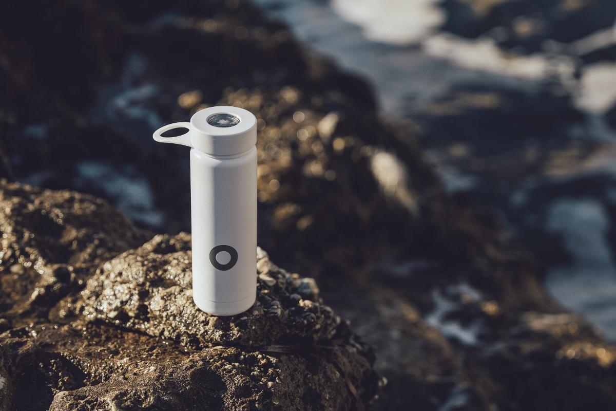 White water bottle resting on rocky terrain