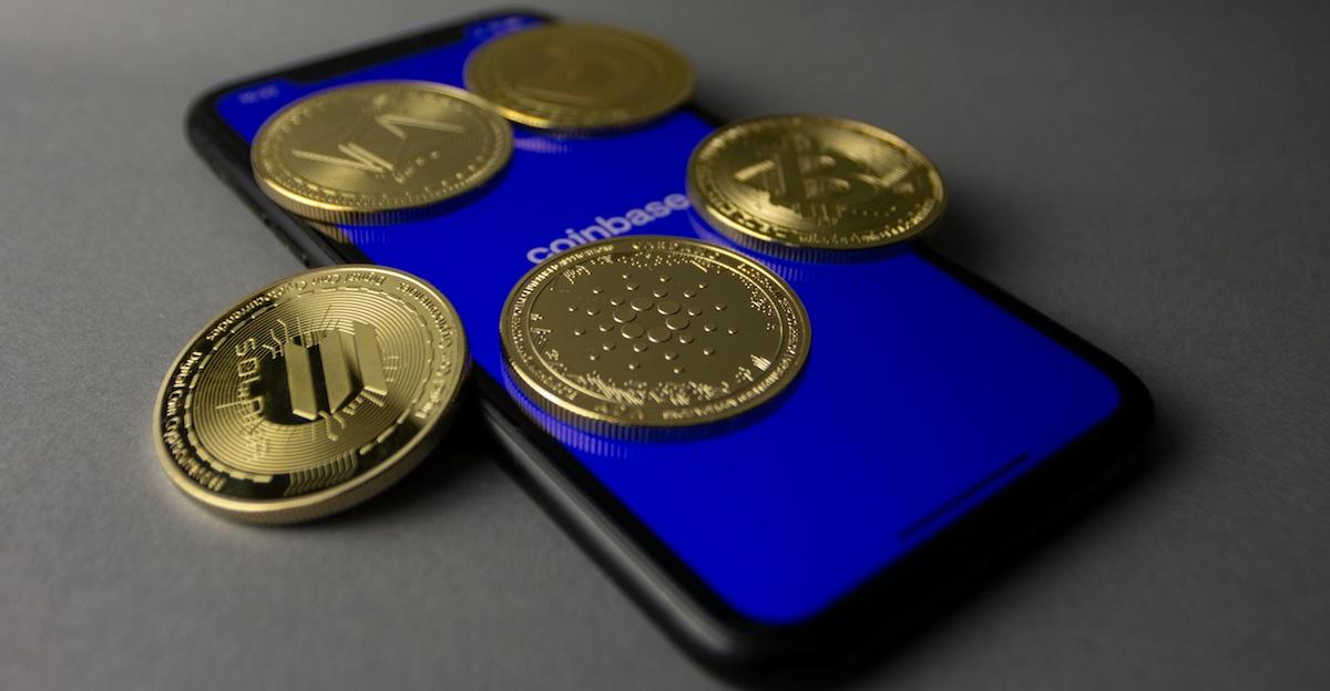 tudio Shot of Gold Bitcoins Lying on Top of a Smart Phone