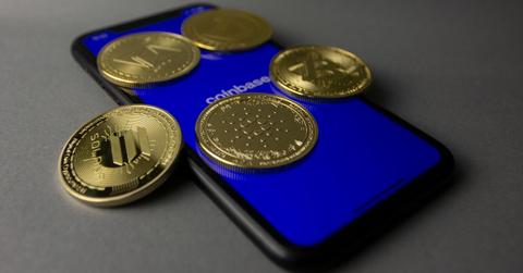 tudio Shot of Gold Bitcoins Lying on Top of a Smart Phone