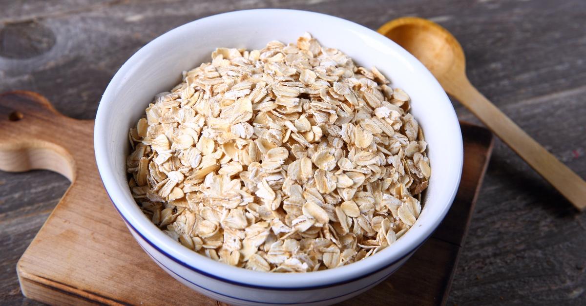 Bowl of oats in a white and blue bowl on a cutting board. 