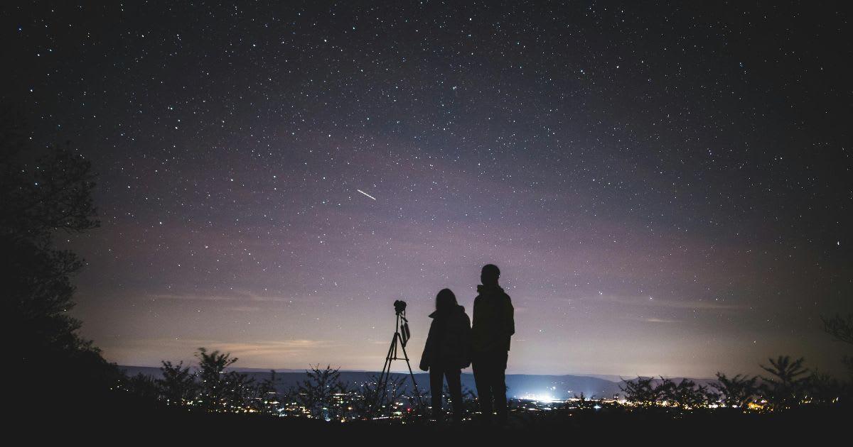 Silhouette of two people watching a meteor shower. (Representative Cover Image Source: Pexels | Yuting Gao)