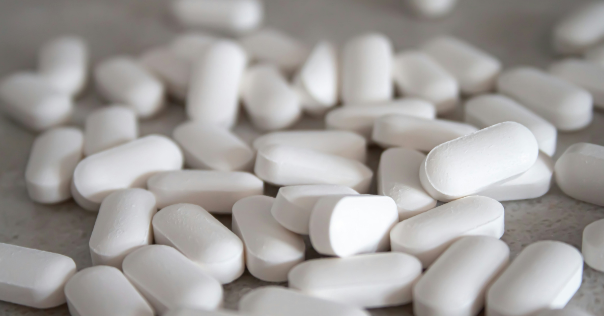 A pile of white pills lay scattered on a counter