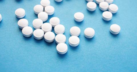 Photograph of spilled pills on a blue counter.