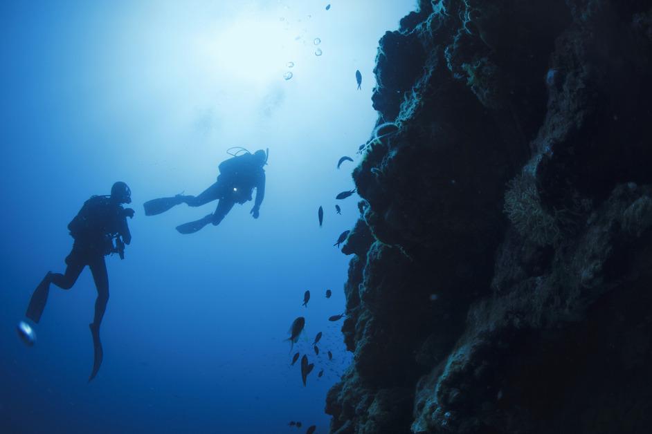 Stock photo of two scuba divers off a  Mediterranean beach. 