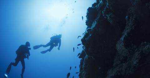 Stock photo of two scuba divers off a Mediterranean beach.