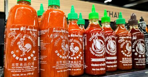 Bottles of Sriracha are lined up on the shelf at the store