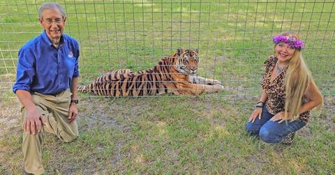 Carole and Howard Baskin crouch next to a tiger.