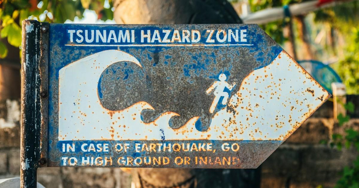 A blue and white sign indicates that the area is part of a tsunami hazard zone