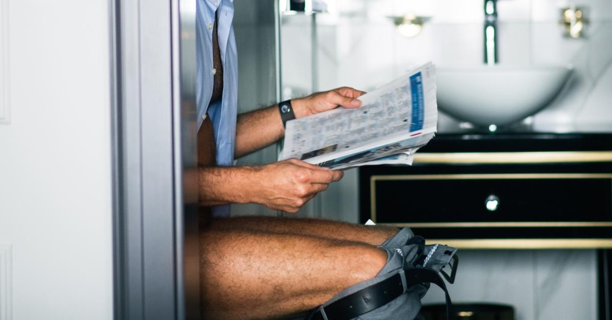 Person reading the news on the toilet in a hotel.