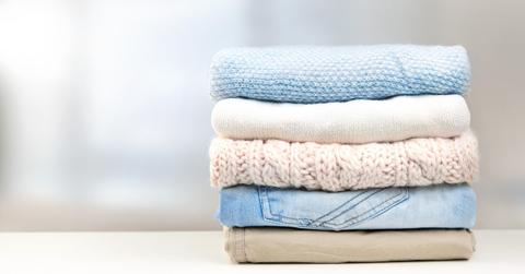 Stack of pastel clothes empty copy space in stock photo