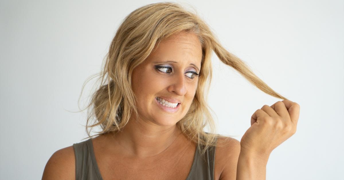 Woman looking at her hair strands.