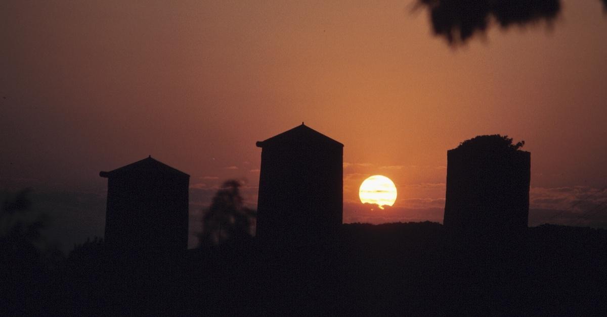 Silhouette of farm silos during a blackout as the sun goes down.