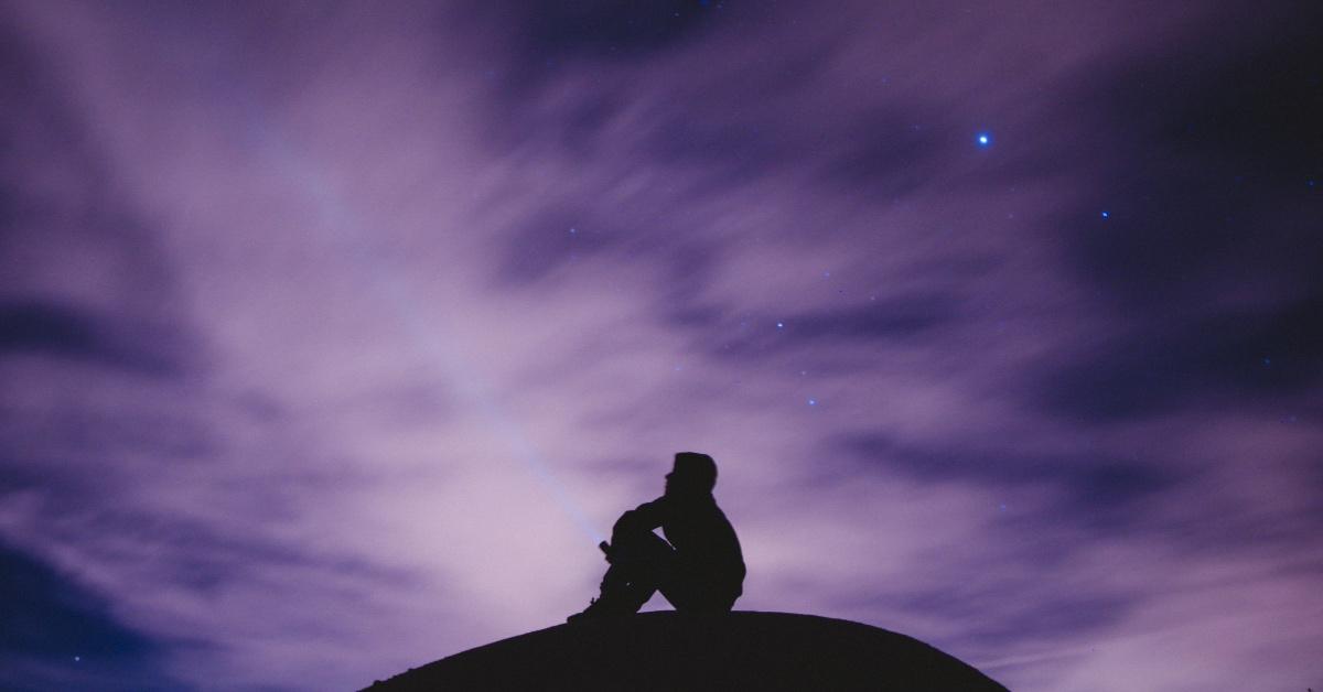 A person looking up at the stars at night. 