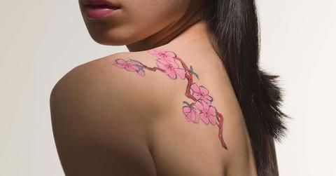 A woman with a cherry blossom tattoo on her shoulder.