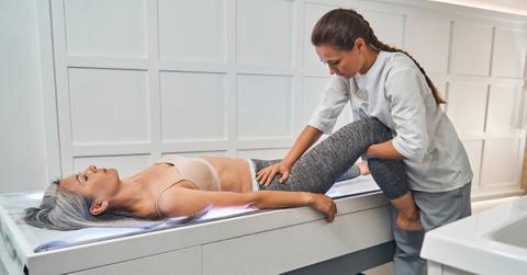 Photo of woman lying on back getting a chiropractic adjustment