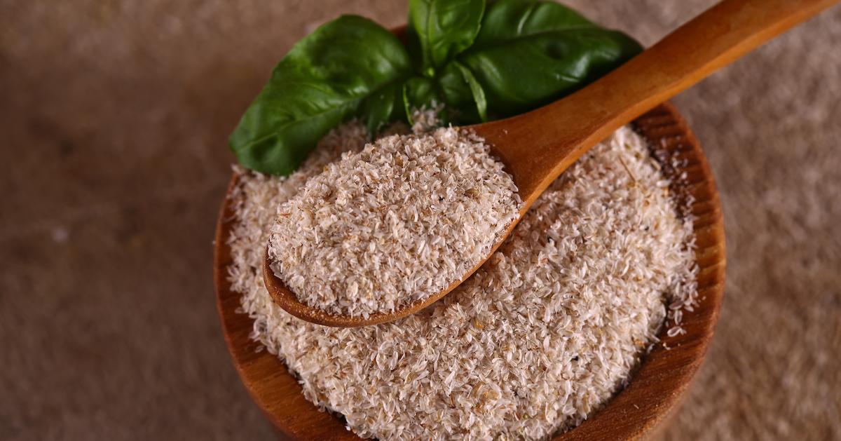 Psyllium fiber in a wooden bowl with a wooden spoon and a leaf garnish