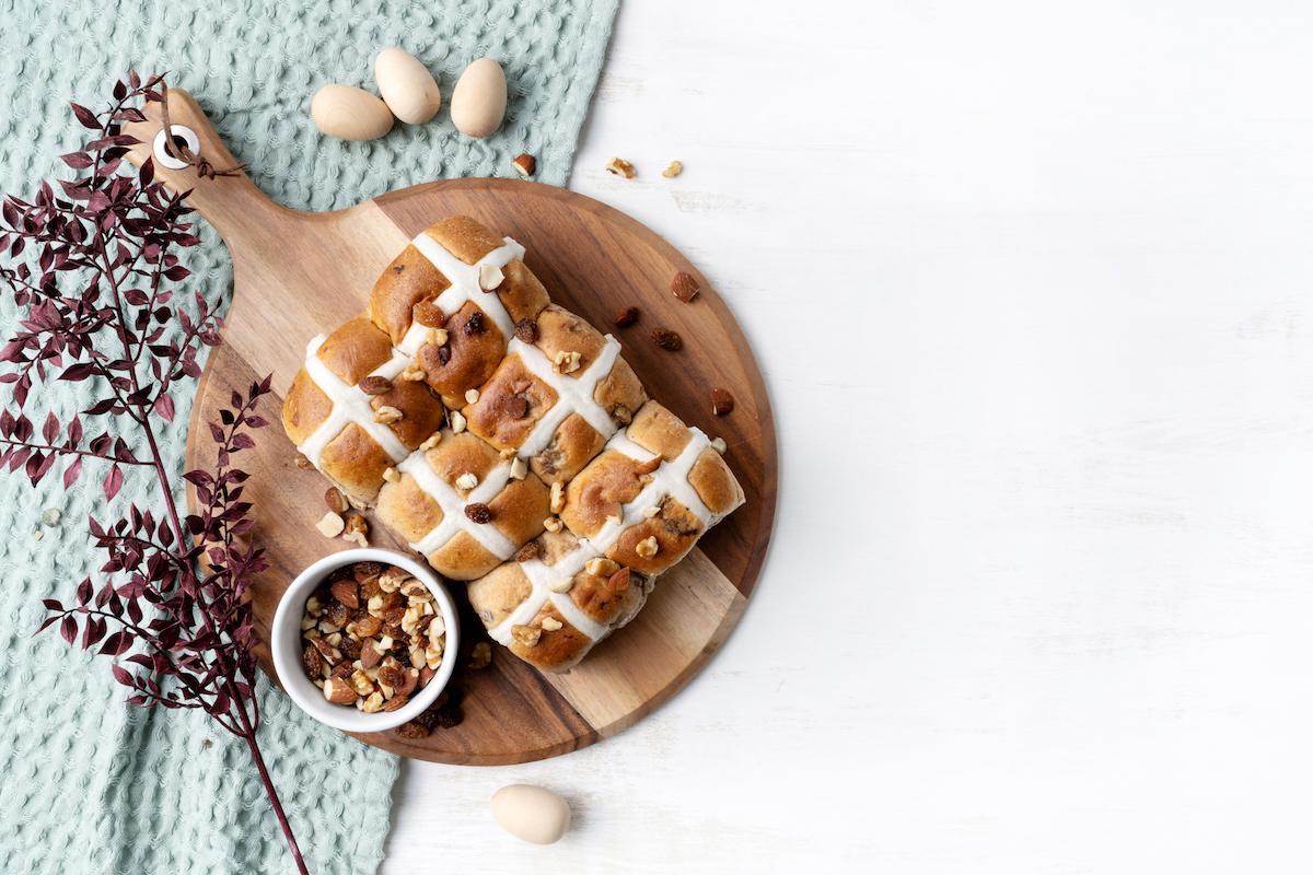 Hot Cross Buns on round wooden cutting board