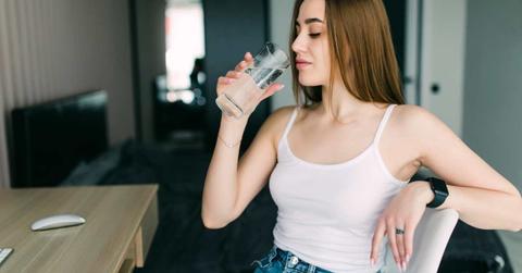A woman is looking at her glass of water before taking a sip. (Representative Cover Image Source: Freepik | diana.grytsku)
