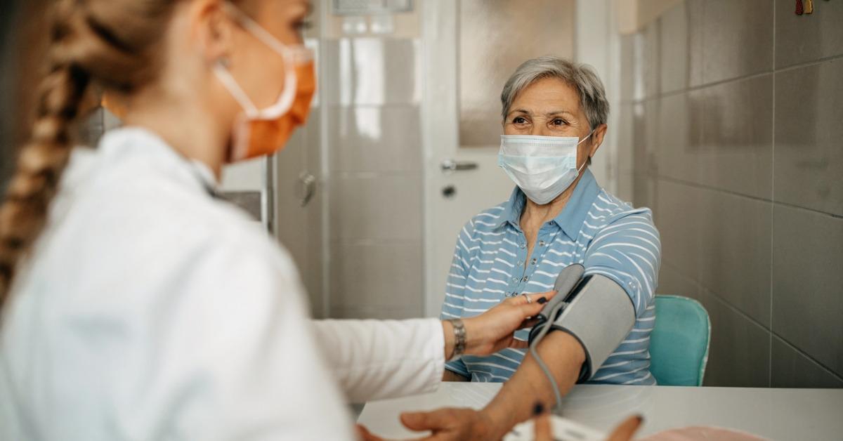 Female doctor checks female patient's blood pressure 