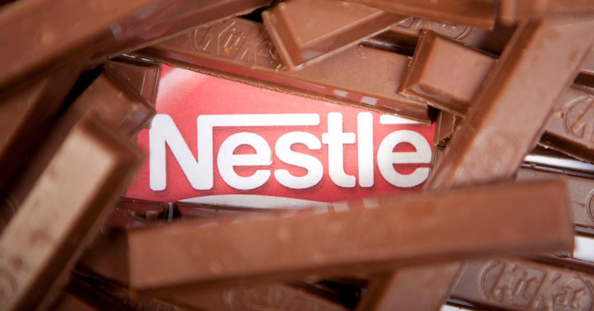 Photo of many unwrapped KitKat chocolate bars surrounding the Nestlé logo