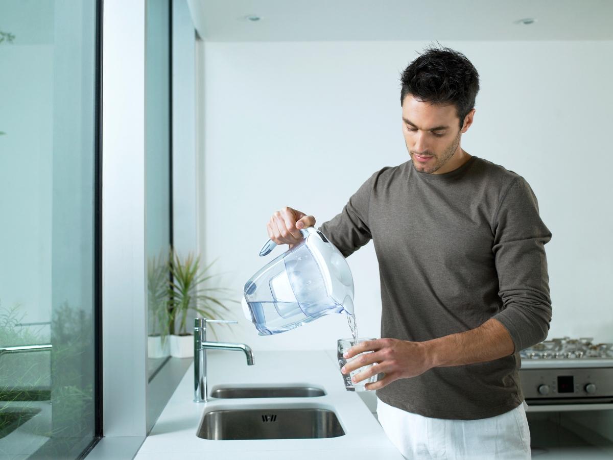 Man pouring water from a filtering container.