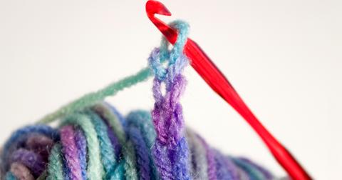A hook holding a chain of four created with a multi-colored yarn.