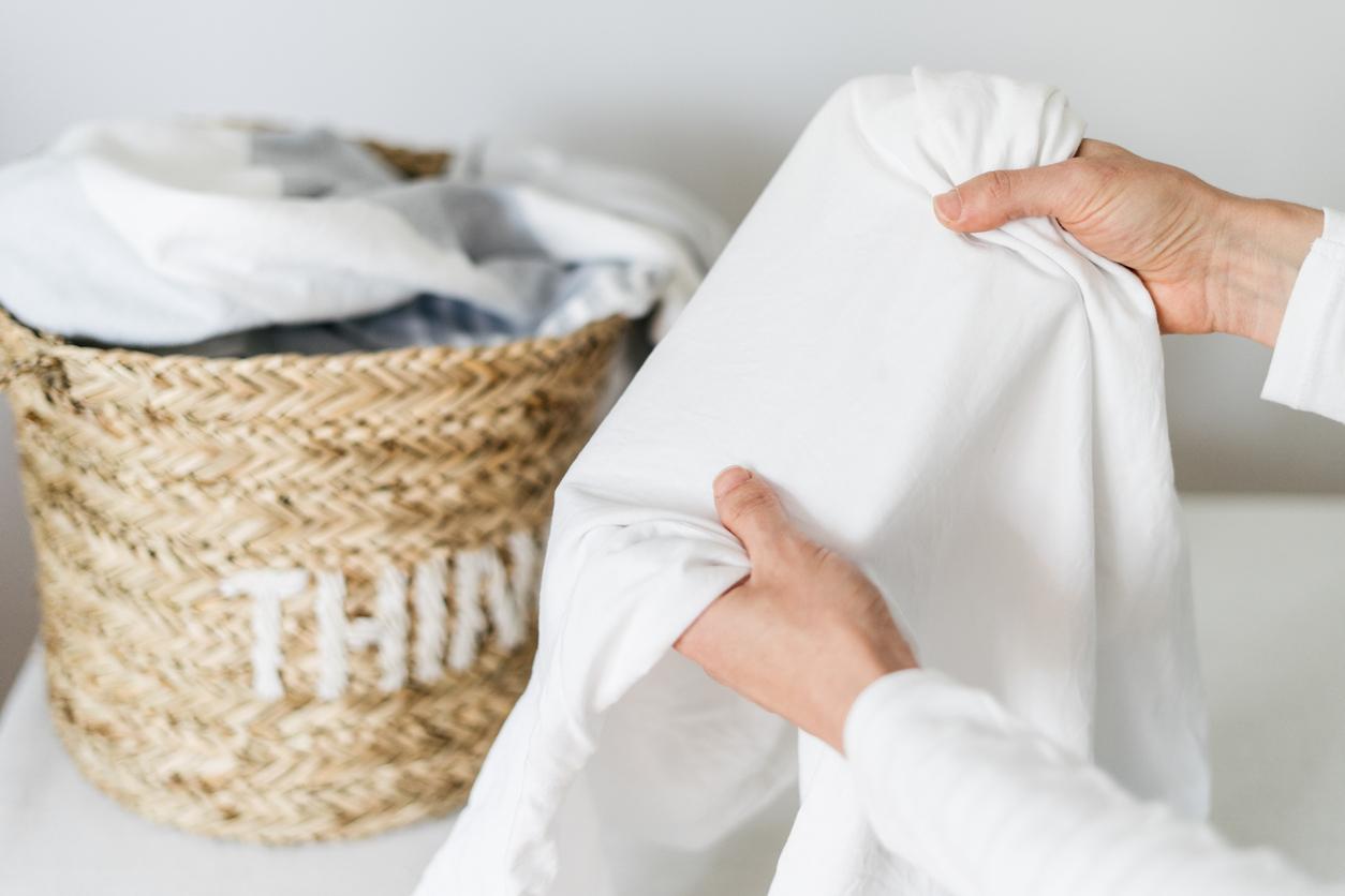 Person holding a white bedding cover.