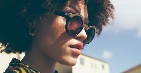 Closeup of woman in sunglasses with afro on sunny day