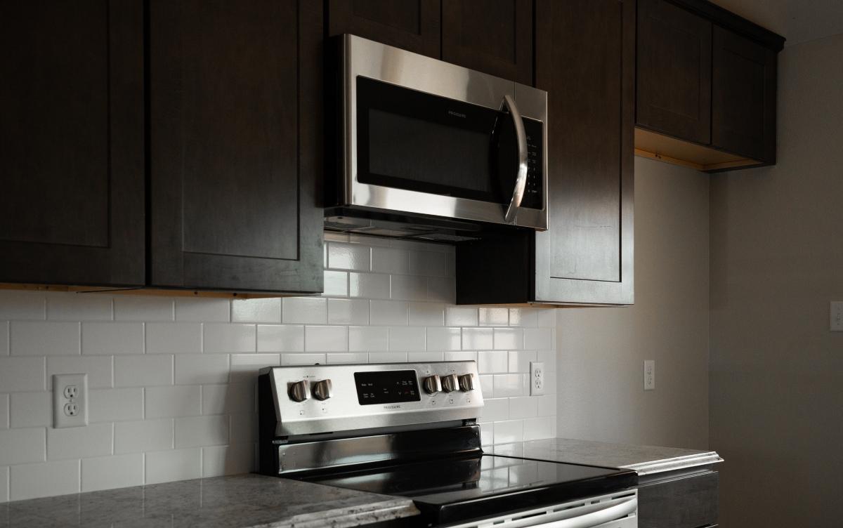 Chrome microwave in a black and white kitchen