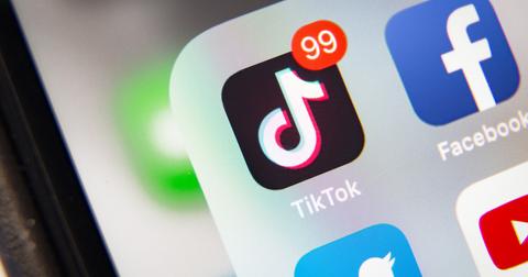 An iPhone screen open to a folder with the Facebook, Youtube, Twitter, and TikTok apps where TikTok has 99 notifications.