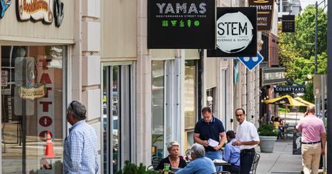 Photo of Winston-Salem, N.C., residents and visitors eating at outdoor tables along a city sidewalk