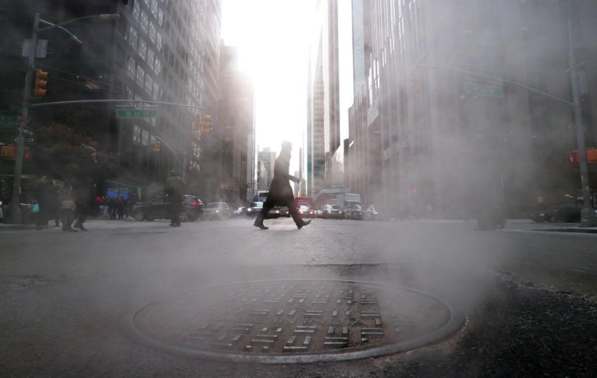 Steam rises from a sewer cover in New York City