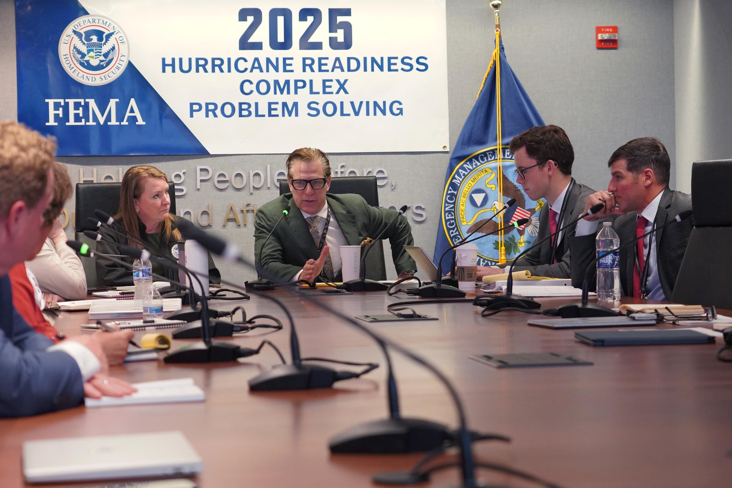 FEMA head David Richardson appears at the center of a FEMA conference table.