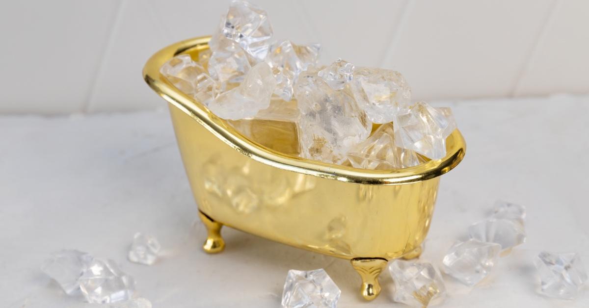 Tiny golden bathtub filled with ice. 