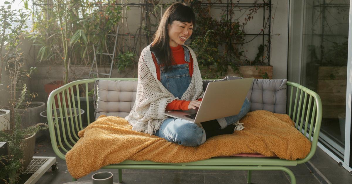 woman sitting outside and shopping on her laptop