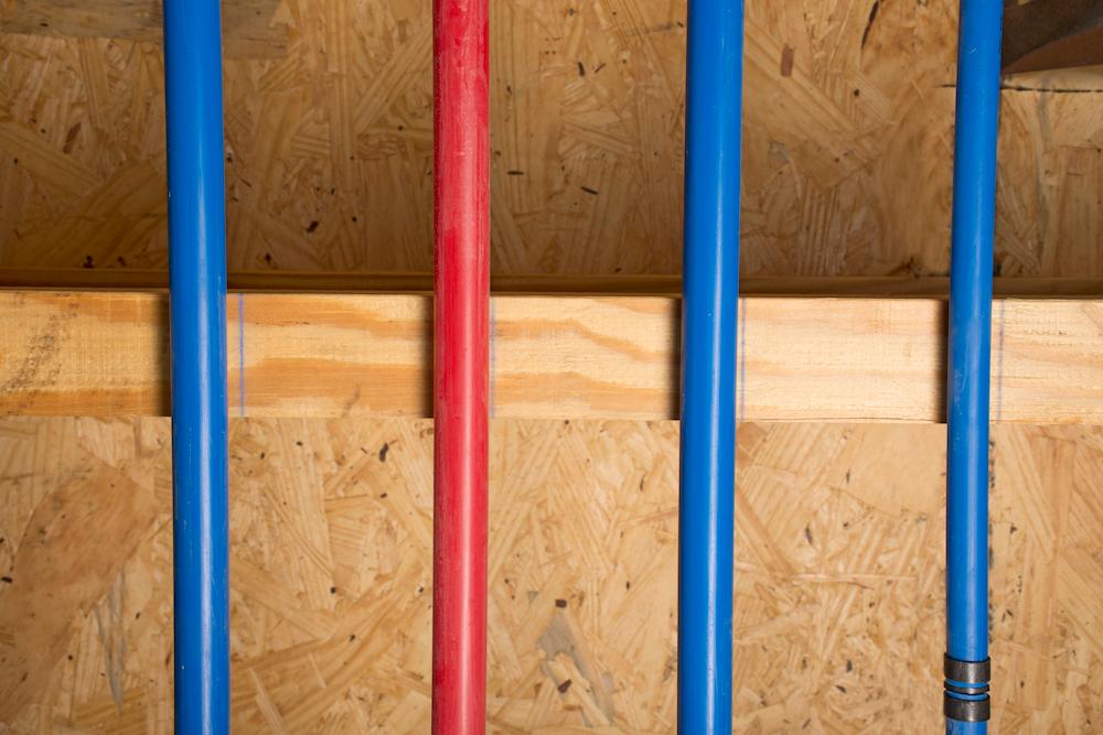 A close up of blue and red vertical PEX pipes.