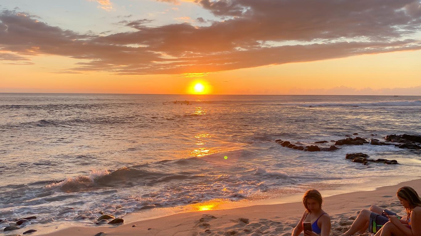 People watching the seemingly distorted and hazy sunset on a beach