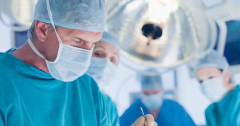 masked surgical team working on a patient