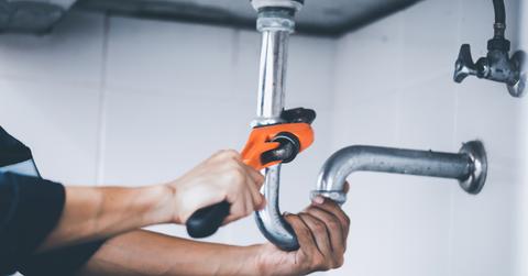 Plumber at work in a bathroom, plumbing repair service, assemble stock photo