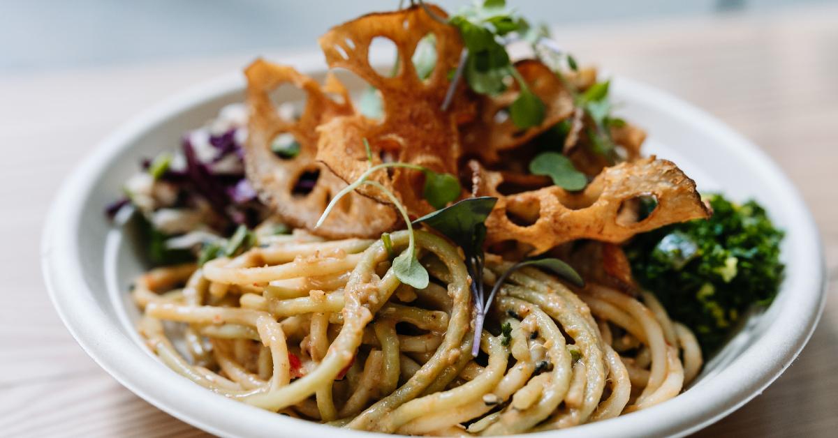 Photo of Plant Junkie's Bangkok Curry Bowl in a white plate on a wooden table